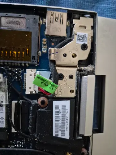 Laptop motherboard with internal components disassembled during repair process